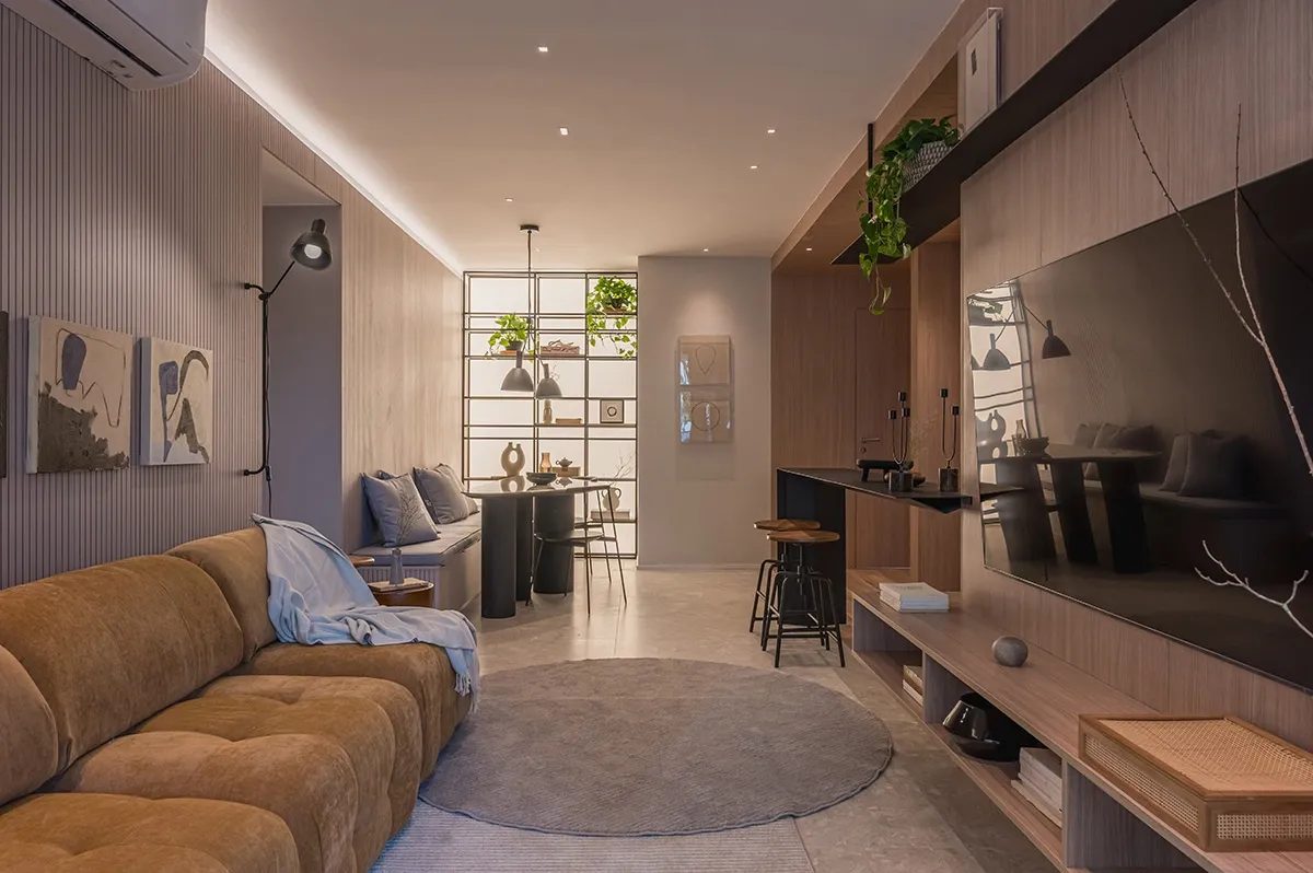Perspectiva ilustrada da sala de estar de um apartamento decorado, com sofá e painel de TV