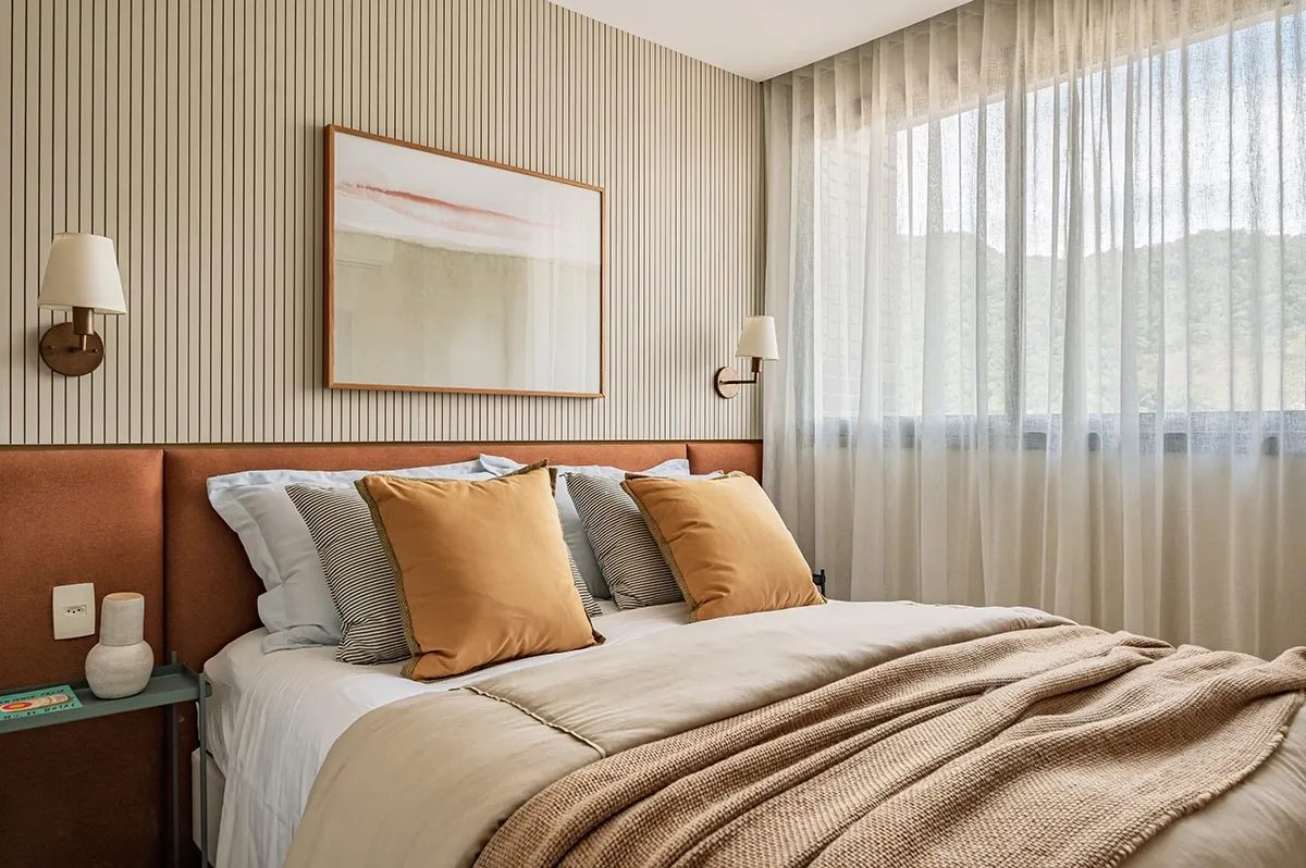 Perspectiva ilustrada da suíte de um apartamento decorado, com cama e cortina